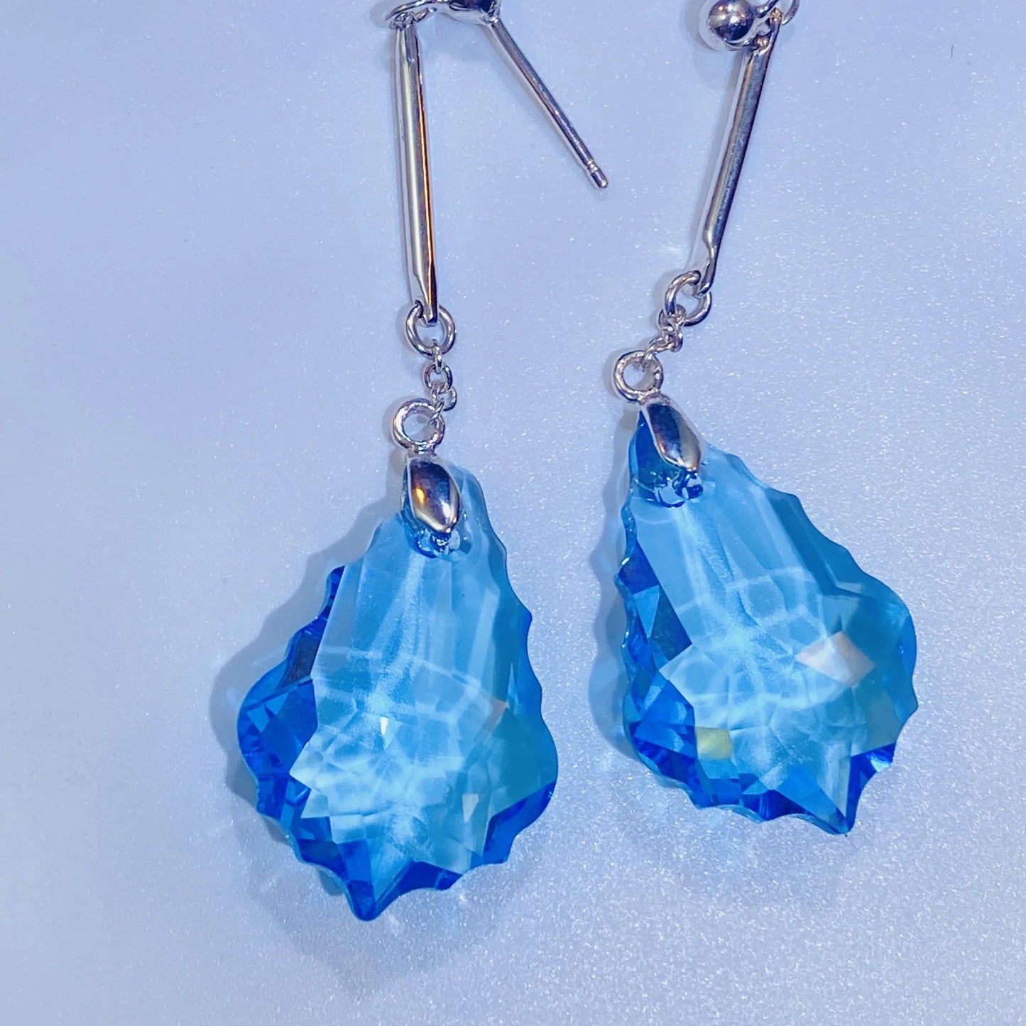 Introduce these stunning sea-blue crystal dangle earrings to your collection. They feature premium, precision-cut crystals with a vivid color and brilliance inspired by top European crystal houses. Crafted from durable 925 sterling silver, these earrings offer a vibrant, luxurious aesthetic. A high-quality, fashionable choice for B2B buyers seeking elegant, color-pop accessories.