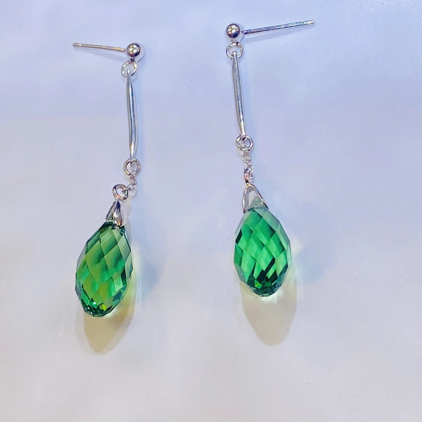 Introduce these sophisticated teardrop dangle earrings to your collection. They feature a premium, precision-cut olive green crystal with a rich color and brilliance inspired by top European crystal houses. Crafted from durable 925 sterling silver, these earrings offer an elegant, luxurious aesthetic. A high-quality, fashionable choice for B2B buyers seeking unique colored, on-trend accessories.