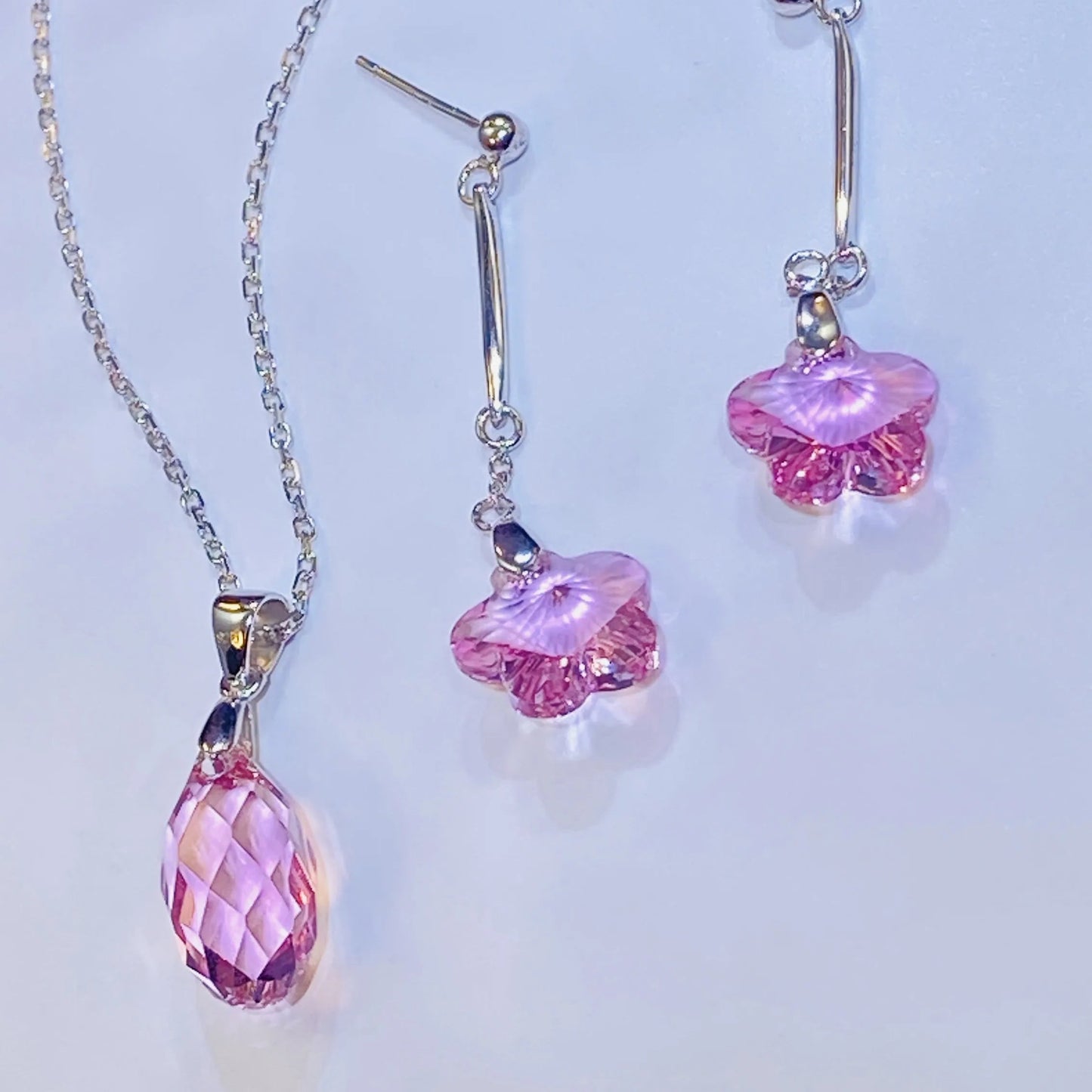 Source these dazzling pink crystal flower drop earrings for your inventory. The central crystals provide exceptional light and color, comparable to leading crystal brands. Set in high-grade 925 sterling silver, this feminine design offers an accessible luxury option. Ideal for wholesale clients looking for popular, high-quality silver jewelry with strong market appeal and an elegant silhouette.