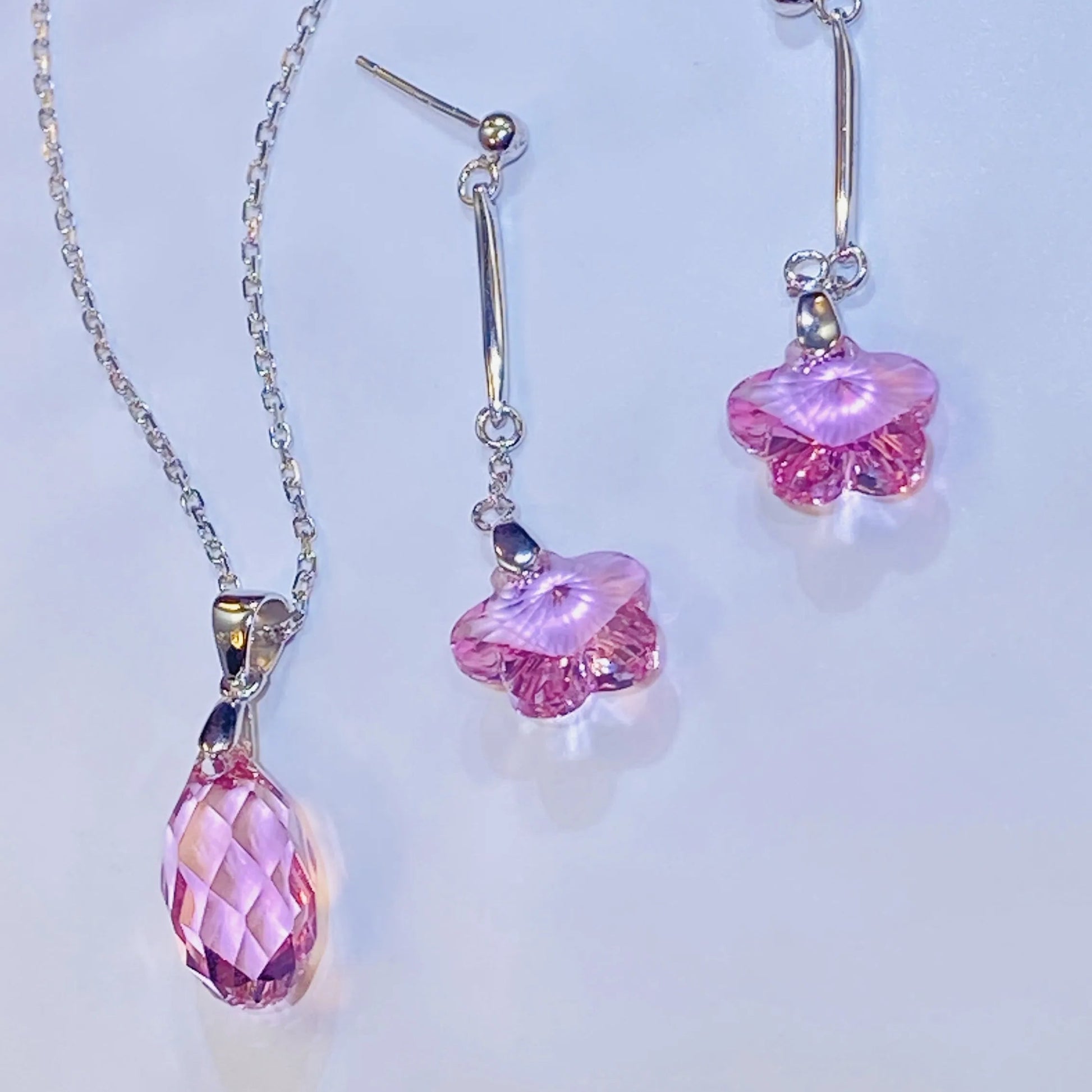 Source these dazzling pink crystal flower drop earrings for your inventory. The central crystals provide exceptional light and color, comparable to leading crystal brands. Set in high-grade 925 sterling silver, this feminine design offers an accessible luxury option. Ideal for wholesale clients looking for popular, high-quality silver jewelry with strong market appeal and an elegant silhouette.