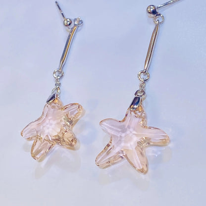 Source these stunning pink crystal starfish earrings for your inventory. The central crystal, in a flattering cherry blossom hue, provides exceptional sparkle, comparable to leading crystal brands. Set in high-grade 925 sterling silver, the unique, coastal-inspired design is both playful and elegant. Ideal for wholesale clients seeking unique, high-quality silver jewelry with strong market appeal.