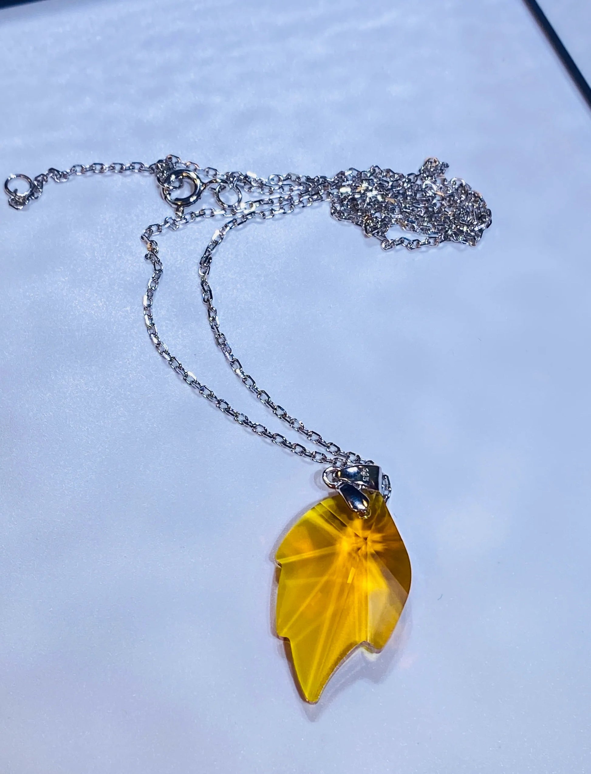 Introduce this vibrant yellow crystal maple leaf pendant to your collection, inspired by popular European designs. Crafted from 925 sterling silver, this piece captures the intricate detail of a maple leaf with a brilliant yellow crystal centerpiece, offering a stylish and seasonal look. A high-demand item perfect for wholesale buyers looking for accessible luxury and current fashion trends.