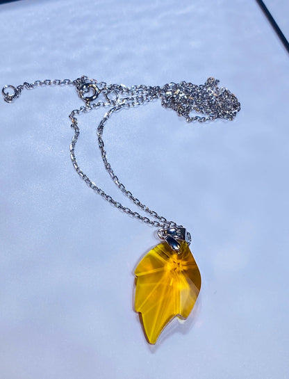 Introduce this vibrant yellow crystal maple leaf pendant to your collection, inspired by popular European designs. Crafted from 925 sterling silver, this piece captures the intricate detail of a maple leaf with a brilliant yellow crystal centerpiece, offering a stylish and seasonal look. A high-demand item perfect for wholesale buyers looking for accessible luxury and current fashion trends.