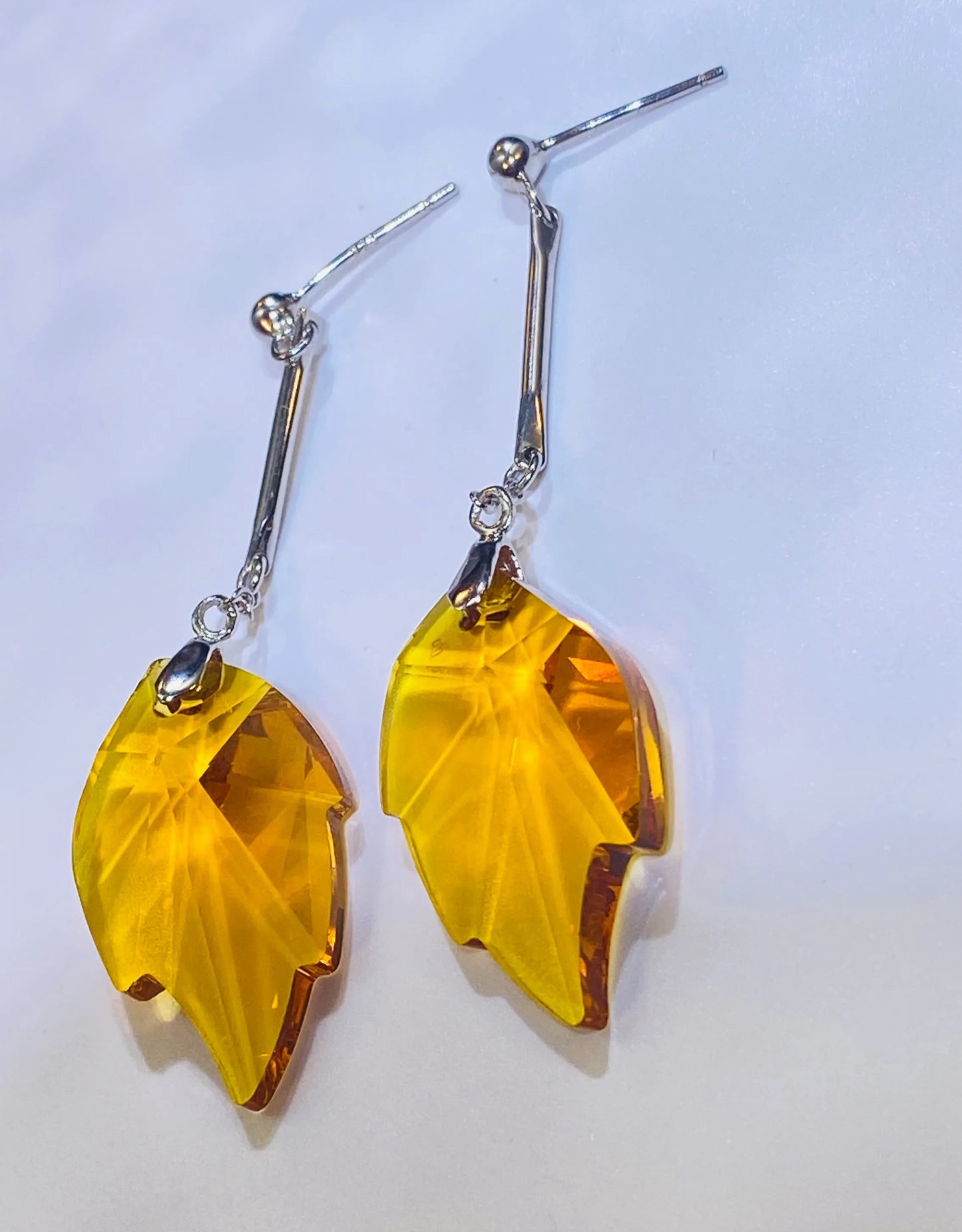 Source these stunning maple leaf earrings, showcasing a brilliant yellow crystal with a sparkle comparable to top crystal brands. The design is set in durable 925 sterling silver. These fashionable dangle earrings provide a luxurious, accessible option for wholesale clients targeting the Western fashion market.