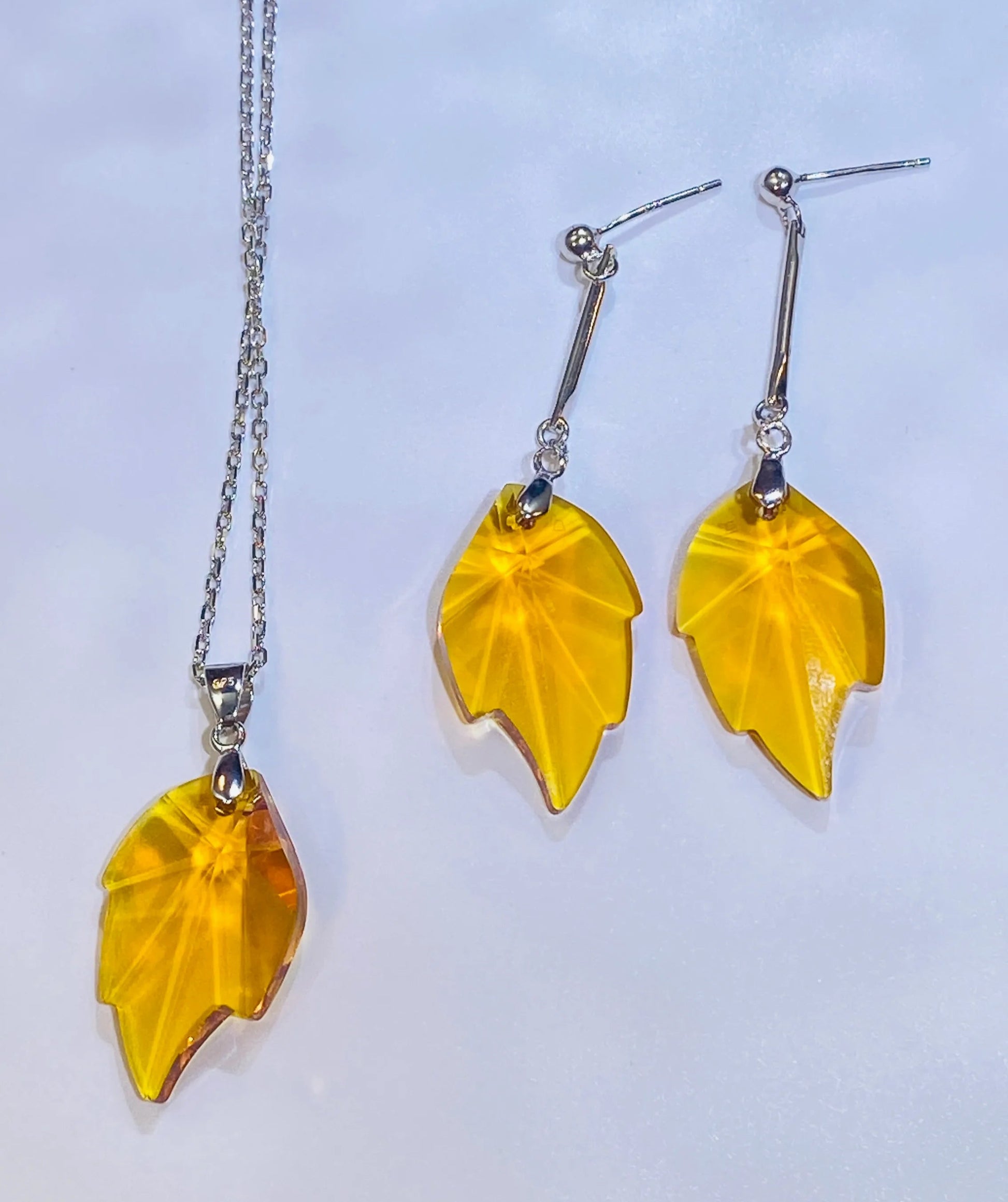 Source these stunning maple leaf earrings, showcasing a brilliant yellow crystal with a sparkle comparable to top crystal brands. The design is set in durable 925 sterling silver. These fashionable dangle earrings provide a luxurious, accessible option for wholesale clients targeting the Western fashion market.