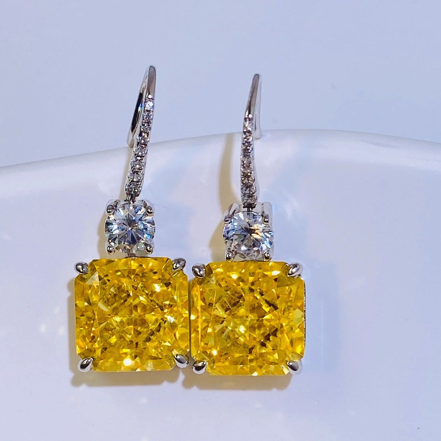These 1cm*1cm yellow sugar cube earrings feature imported high-carbon diamonds for a dazzling, translucent look. The flexible hook connection creates a dynamic and versatile design, perfect for women. Made from 925 sterling silver with four layers of genuine gold plating, they're resistant to oxidation and allergies.