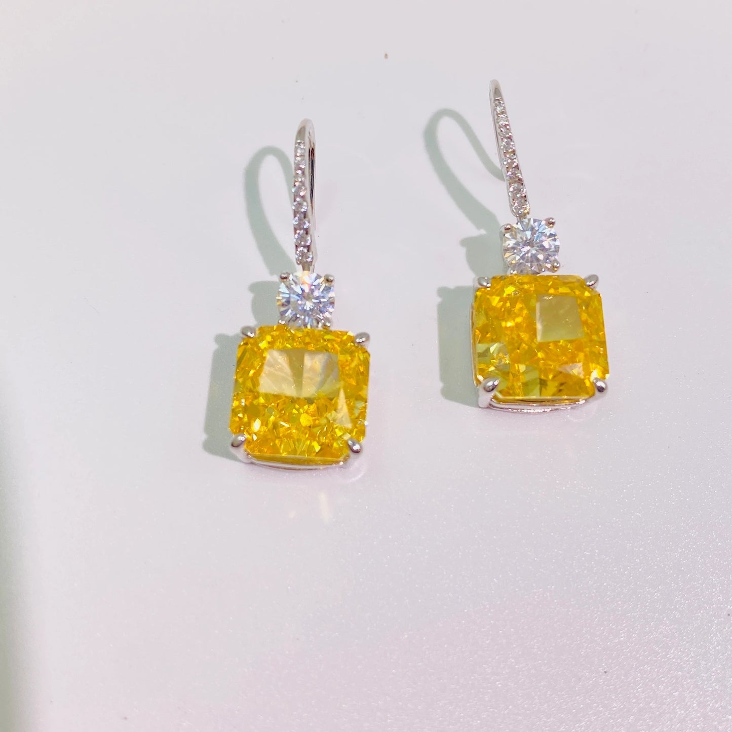 These 1cm*1cm yellow sugar cube earrings feature imported high-carbon diamonds for a dazzling, translucent look. The flexible hook connection creates a dynamic and versatile design, perfect for women. Made from 925 sterling silver with four layers of genuine gold plating, they're resistant to oxidation and allergies.