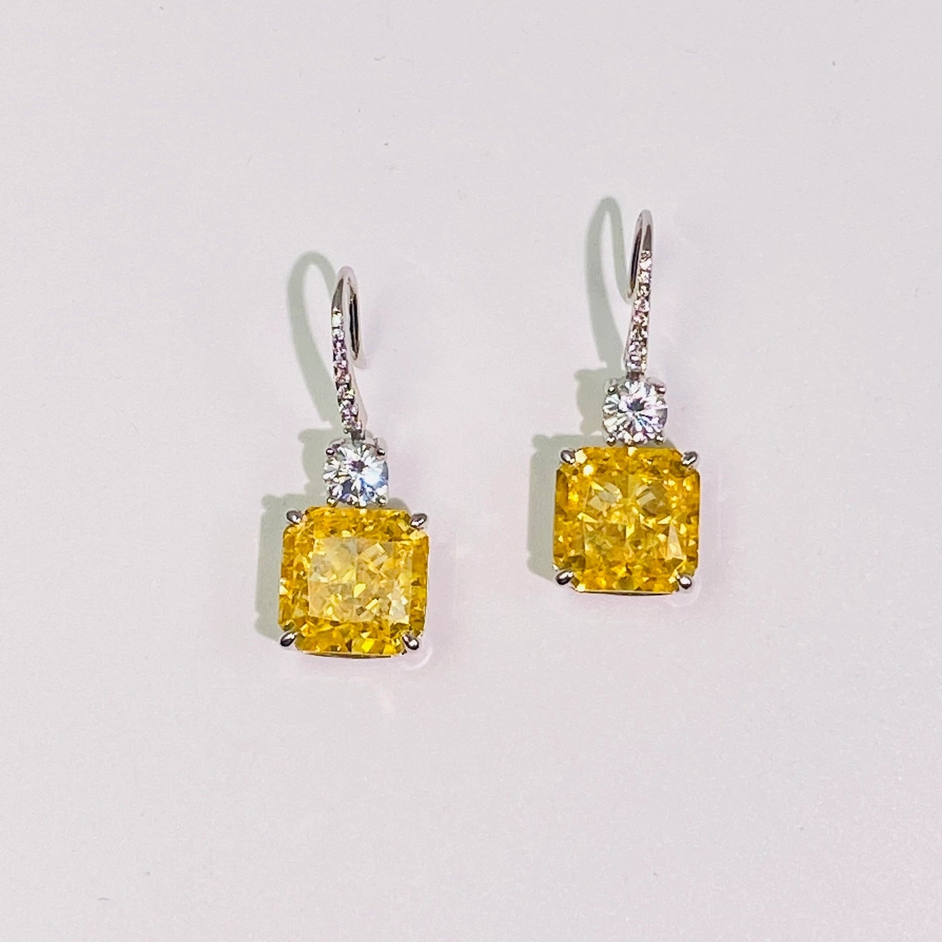 These 1cm*1cm yellow sugar cube earrings feature imported high-carbon diamonds for a dazzling, translucent look. The flexible hook connection creates a dynamic and versatile design, perfect for women. Made from 925 sterling silver with four layers of genuine gold plating, they're resistant to oxidation and allergies.