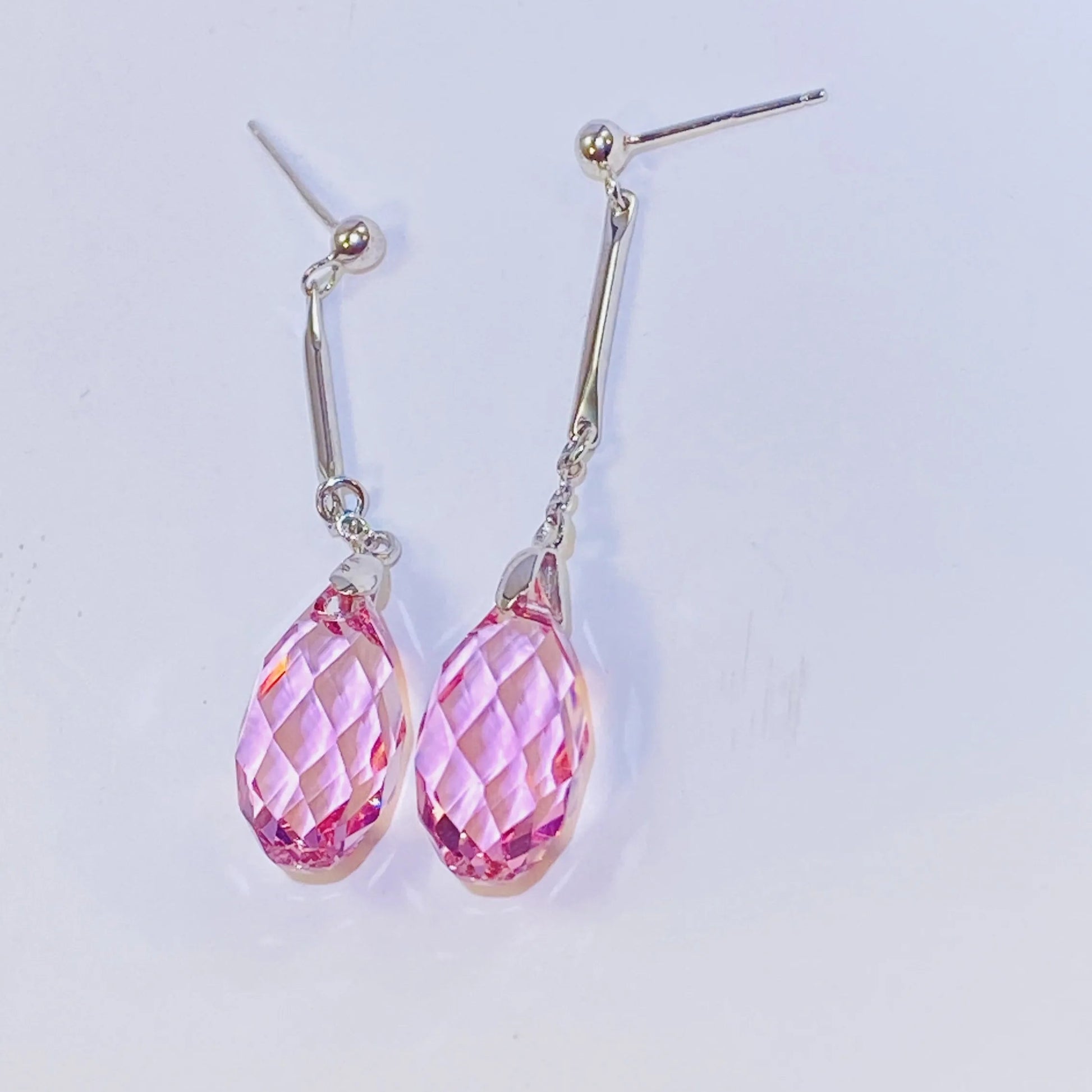 Introduce these elegant teardrop dangle earrings to your collection. They feature premium, precision-cut pink crystals with a stunning clarity and sparkle inspired by top European crystal houses. Crafted from durable 925 sterling silver, these earrings offer a sophisticated, luxurious aesthetic. A high-quality, fashionable choice for B2B buyers seeking timeless yet on-trend accessories.