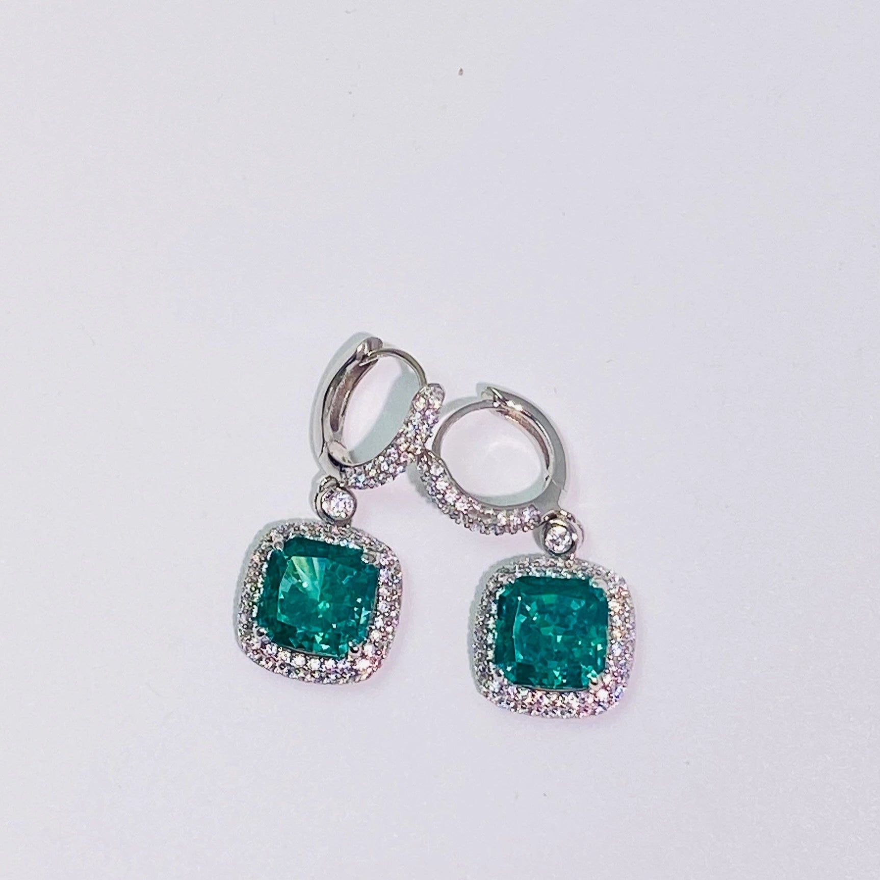 Imported Paraiba 8*8mm hand-cut 5A-grade high-carbon diamonds are used to create a dazzling, translucent look. The ear hook connection is flexible and dynamic, making it suitable for women. The entire piece is made of 925 sterling silver with four layers of gold plating, which is anti-oxidation and non-allergenic.