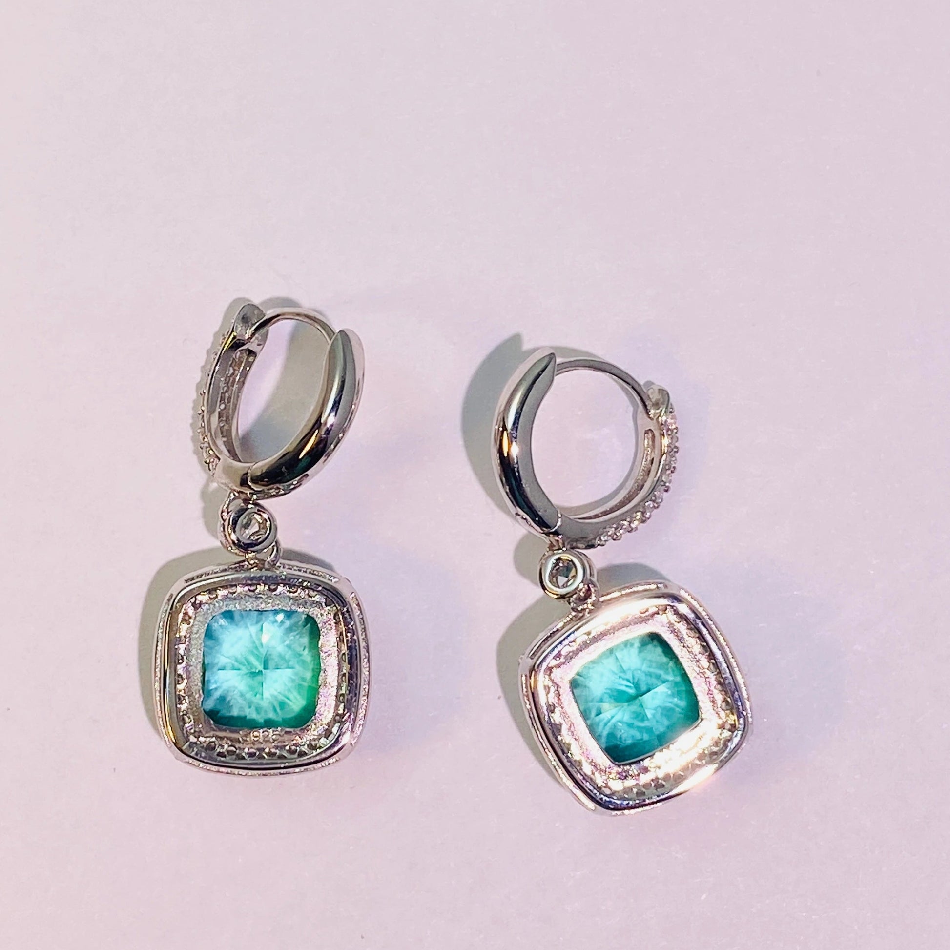 Imported Paraiba 8*8mm hand-cut 5A-grade high-carbon diamonds are used to create a dazzling, translucent look. The ear hook connection is flexible and dynamic, making it suitable for women. The entire piece is made of 925 sterling silver with four layers of gold plating, which is anti-oxidation and non-allergenic.