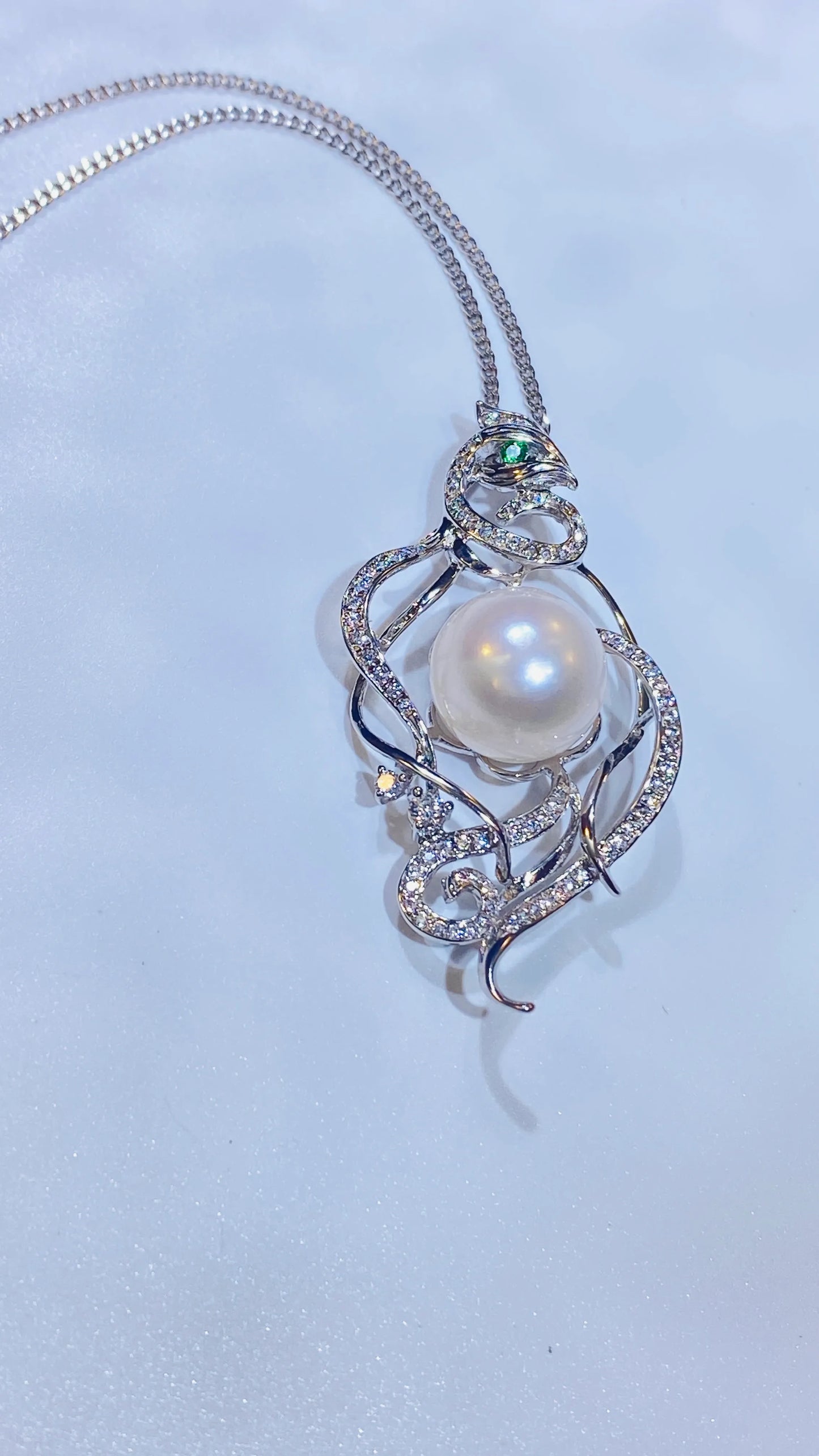 Embrace a piece with a story. Our stunning phoenix necklace draws inspiration from ancient Chinese culture, representing a woman's free-spirited and elegant nature. Made with fine gold-plated silver, the detailed phoenix design features a captivating green zircon eye and is adorned with genuine freshwater pearls. It's a truly creative and distinctive accessory that stands out from the crowd.