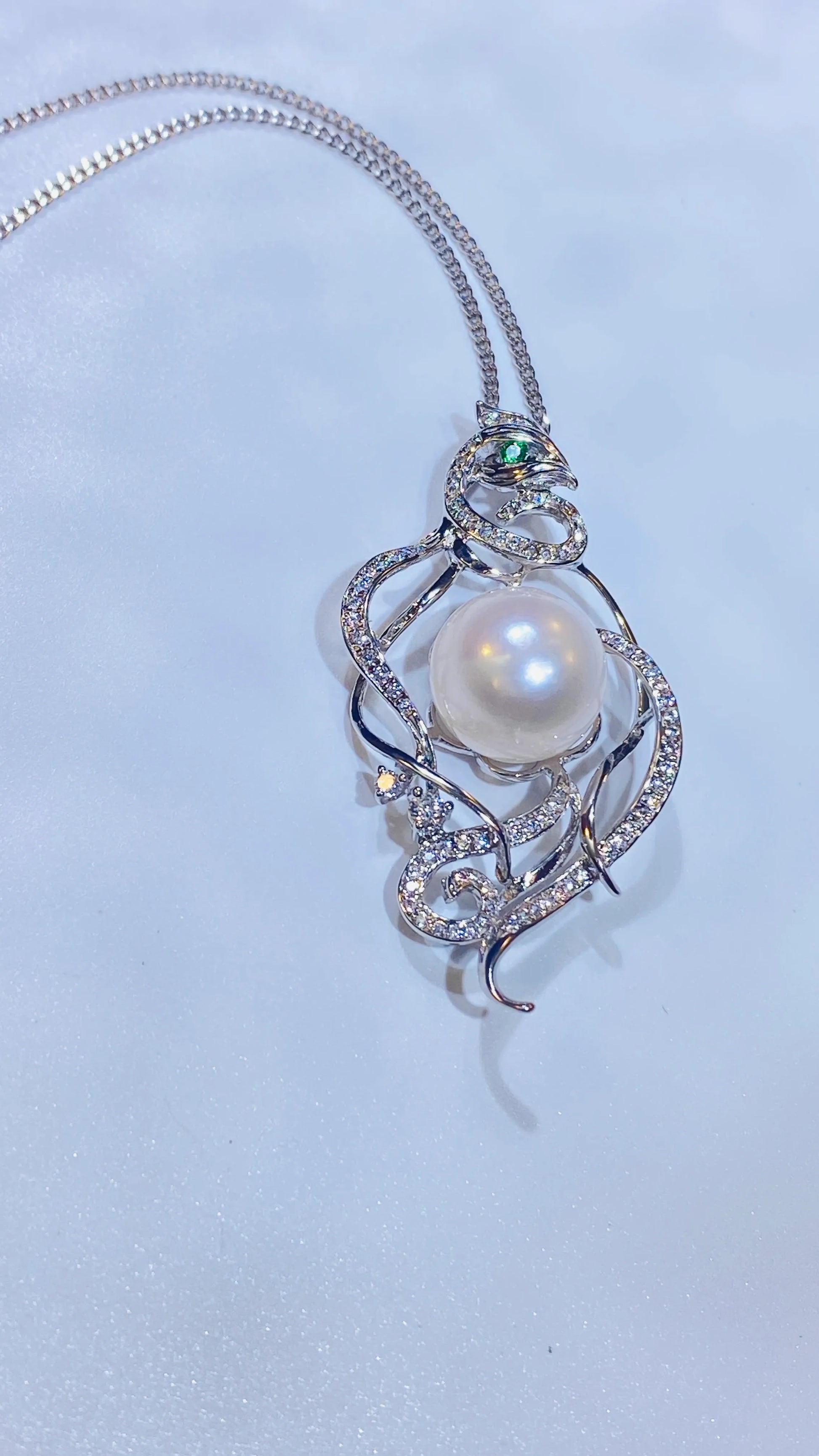 Embrace a piece with a story. Our stunning phoenix necklace draws inspiration from ancient Chinese culture, representing a woman's free-spirited and elegant nature. Made with fine gold-plated silver, the detailed phoenix design features a captivating green zircon eye and is adorned with genuine freshwater pearls. It's a truly creative and distinctive accessory that stands out from the crowd.