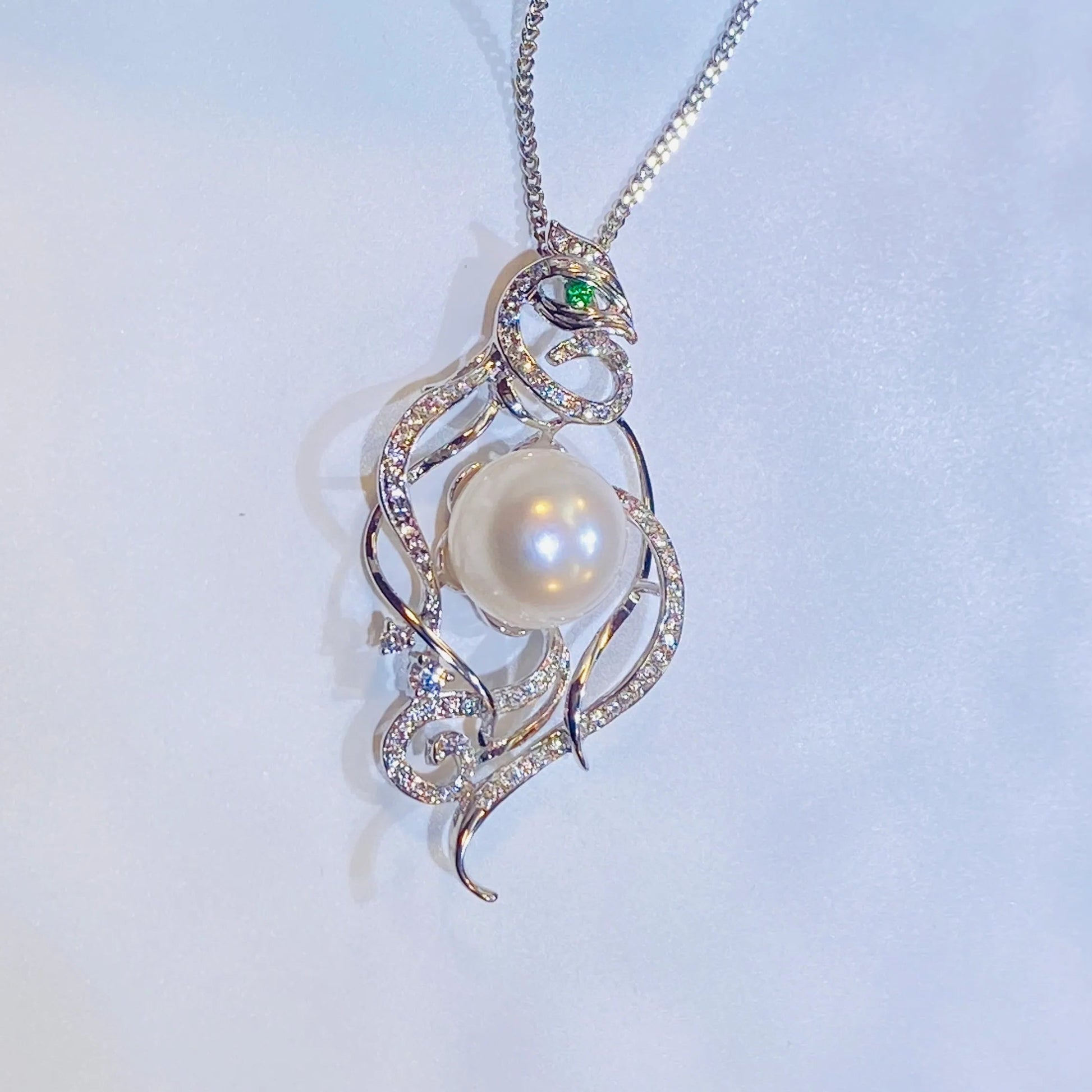 Embrace a piece with a story. Our stunning phoenix necklace draws inspiration from ancient Chinese culture, representing a woman's free-spirited and elegant nature. Made with fine gold-plated silver, the detailed phoenix design features a captivating green zircon eye and is adorned with genuine freshwater pearls. It's a truly creative and distinctive accessory that stands out from the crowd.