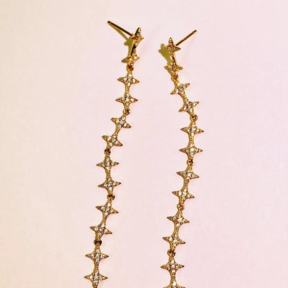 These exquisite, long star chain dangle earrings are crafted with 5A grade imported zircon and feature a thick 1.0um champagne gold plating. Our advanced silver-to-K gold plating process achieves the luxury look and feel of fine gold jewelry, perfect for discerning B2B buyers seeking high-quality, fashion-forward pieces.