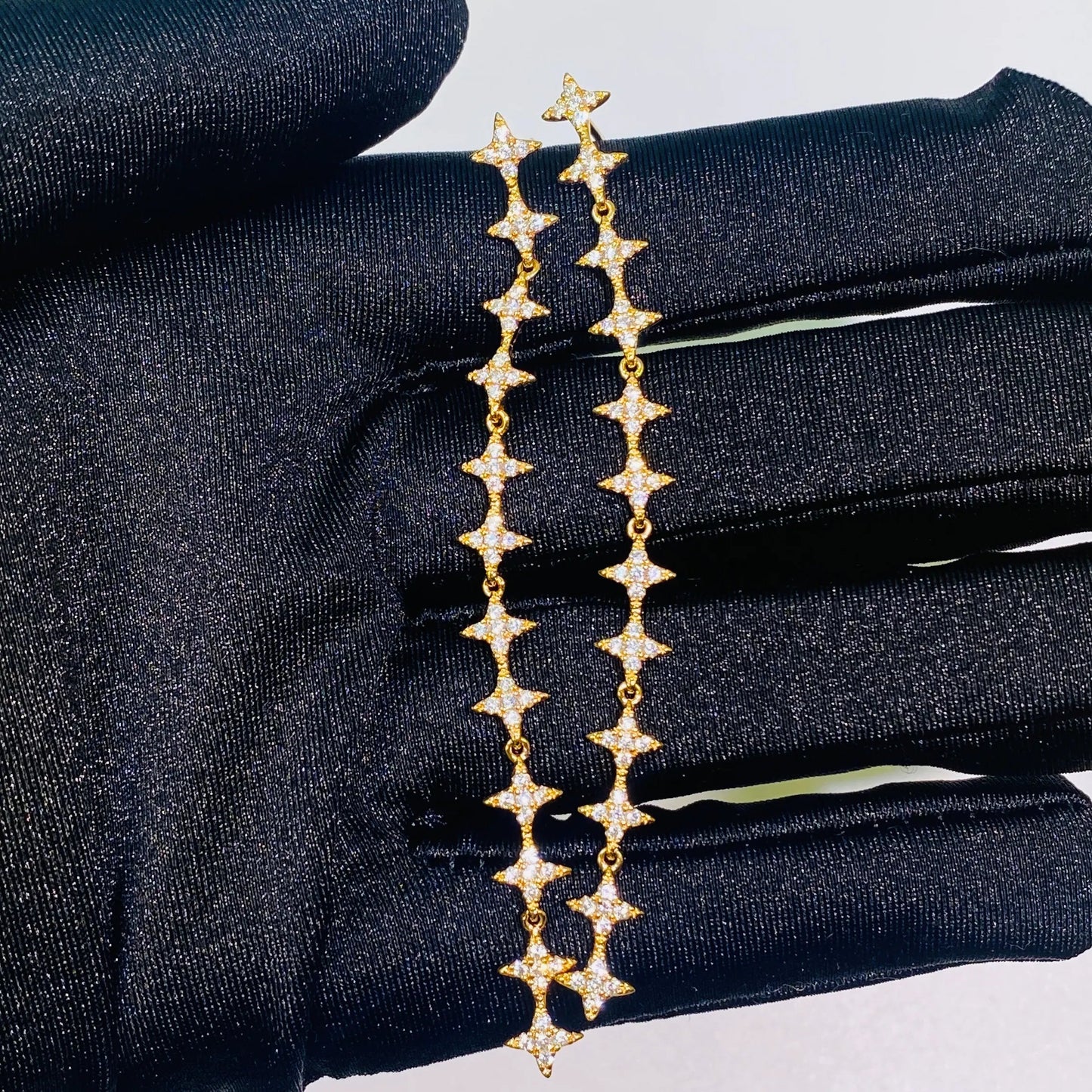 These exquisite, long star chain dangle earrings are crafted with 5A grade imported zircon and feature a thick 1.0um champagne gold plating. Our advanced silver-to-K gold plating process achieves the luxury look and feel of fine gold jewelry, perfect for discerning B2B buyers seeking high-quality, fashion-forward pieces.