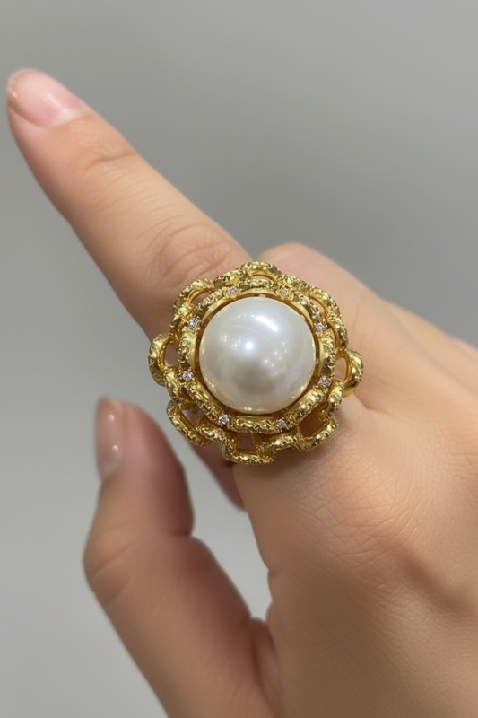 Model hand wearing silver open lattice braided wreath white pearl cocktail ring, luxury jewelry editorial